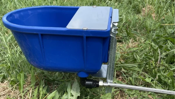 Abbeveratoio FAAG POLIPROP blu fissato su staffa FAR 23 da terra, installato su prato con collegamento acqua flessibile